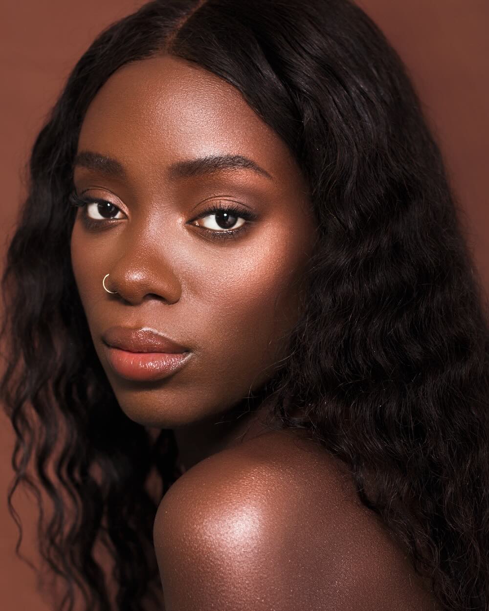 Awa Touray with dark skin makeup and Cinnamon Bronze Shimmer Pigment for highlighter